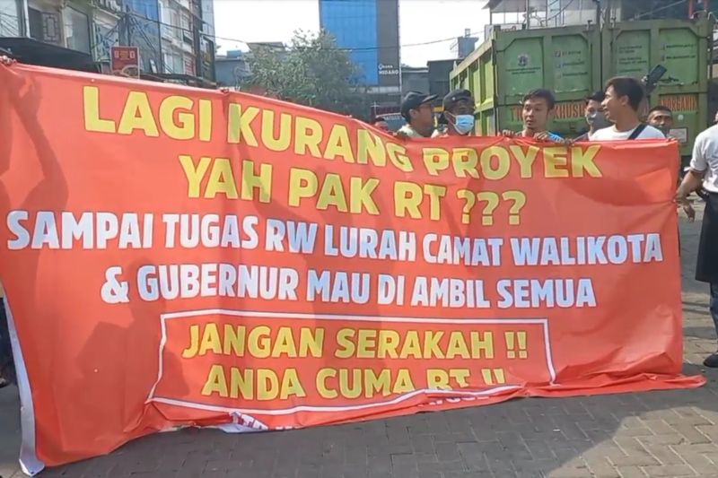 Sekelompok orang di Pluit Karang Niaga RT011/RW03 membentangkan spanduk merah menyuarakan aspirasi mereka terhadap Ketua RT setempat Riang Prasetya karena aduannya membuat bangunan ruko mereka dibongkar petugas terpadu di Jakarta Utara, Rabu (24/5/2023). (ant)